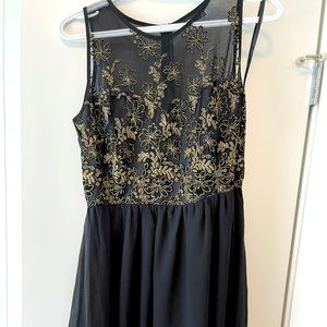 Cute black dress with gold details on top.